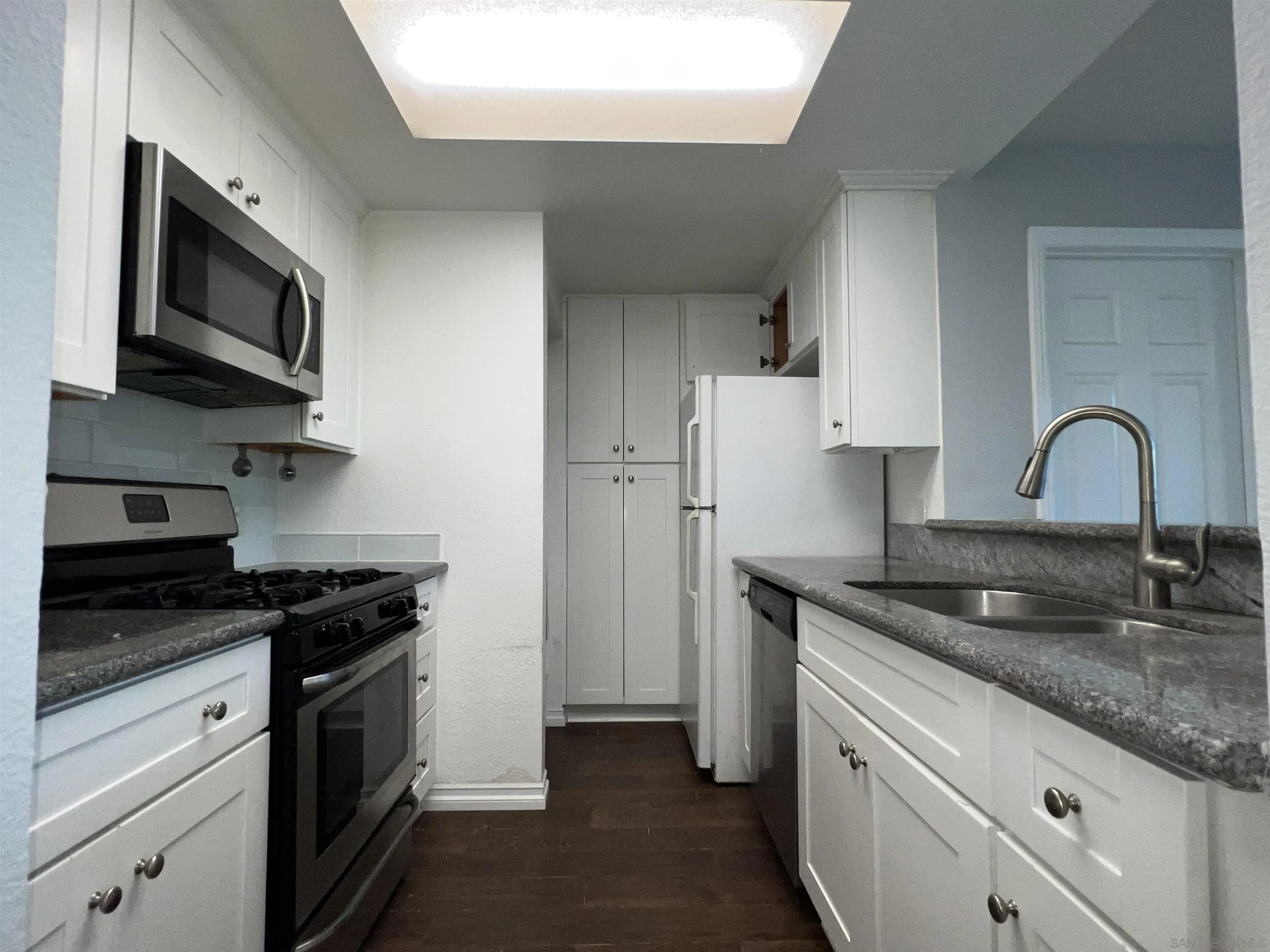 3043 Chipwood Court Spring Valley, CA 91978 - Photo 10 of 38 a kitchen with granite countertop white cabinets and stainless steel appliances
