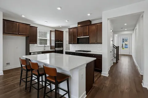 a kitchen with stainless steel appliances granite countertop refrigerator sink and wooden cabinets