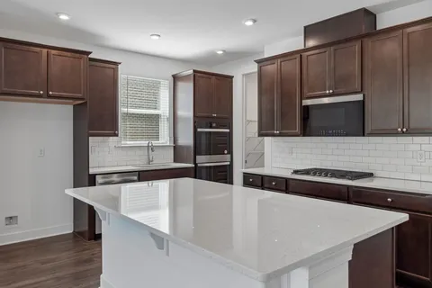 a kitchen with stainless steel appliances granite countertop a sink and a refrigerator