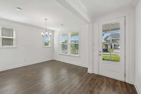 a view of an empty room with wooden floor and staircase