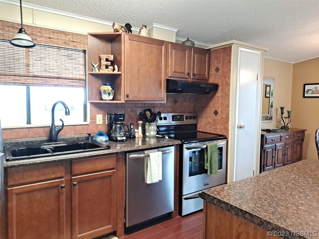 4330 Whiting Way Edgewater, FL 32141 - Photo 10 of 30 a kitchen with stainless steel appliances granite countertop a sink stove and refrigerator