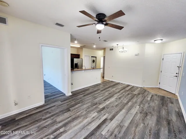 a view of a livingroom with wooden floor and a ceiling fan