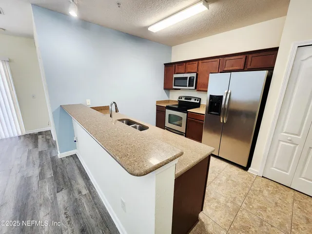 a kitchen with stainless steel appliances cabinets and wooden floor