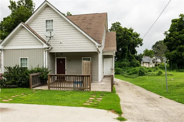 a view of a house with a yard and potted plants