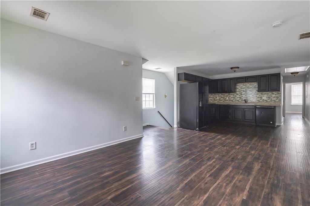 1607 Ralph David Abernathy Boulevard Southwest Atlanta, GA 30310 - Photo 2 of 16 a view of empty room with wooden floor and kitchen view