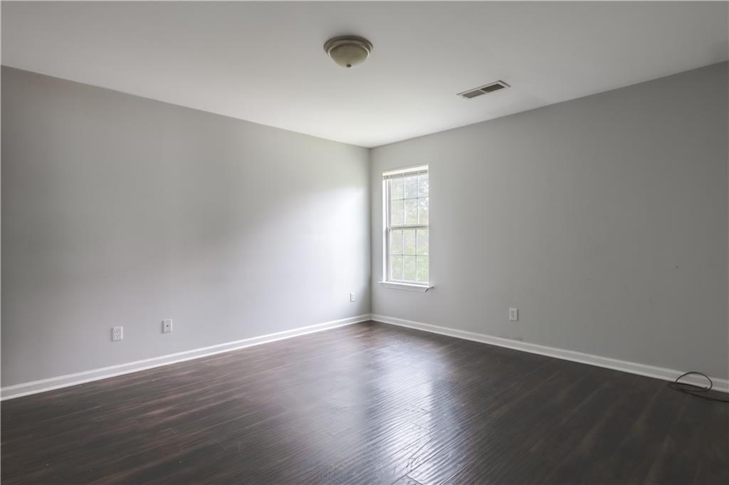 1607 Ralph David Abernathy Boulevard Southwest Atlanta, GA 30310 - Photo 5 of 16 an empty room with wooden floor and windows