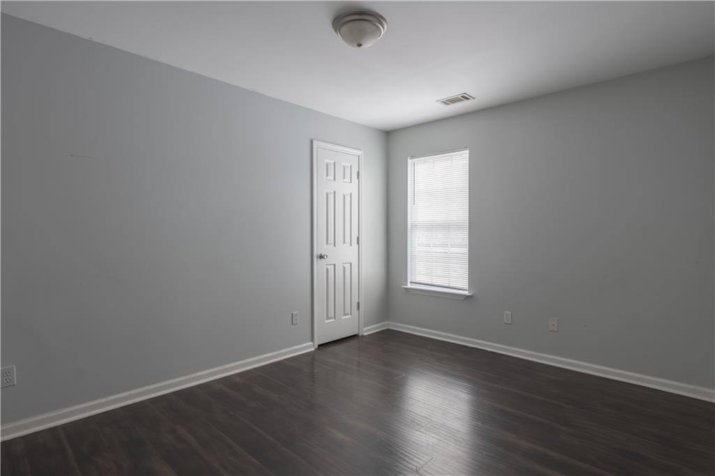 1607 Ralph David Abernathy Boulevard Southwest Atlanta, GA 30310 - Photo 8 of 16 an empty room with wooden floor and windows