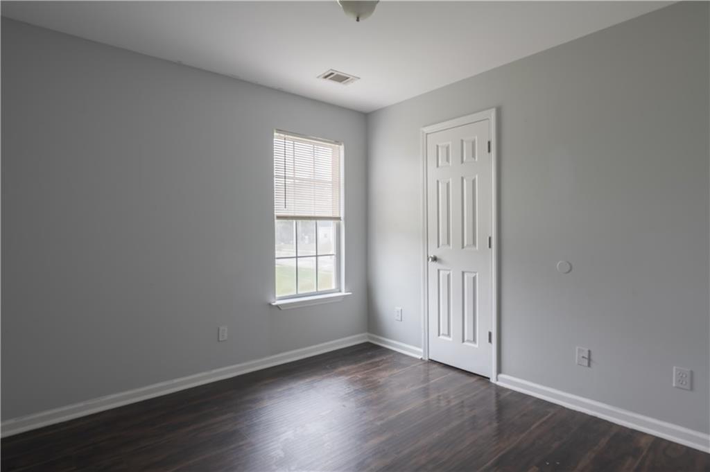 1607 Ralph David Abernathy Boulevard Southwest Atlanta, GA 30310 - Photo 10 of 16 an empty room with wooden floor and windows