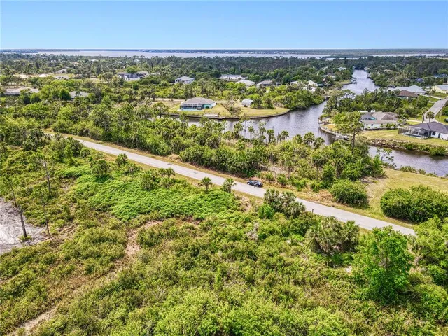 an aerial view of residential houses with outdoor space and trees