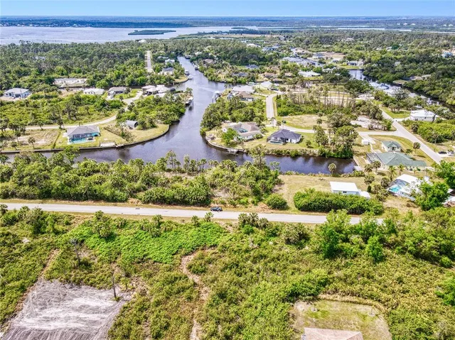 an aerial view of residential houses with outdoor space and trees
