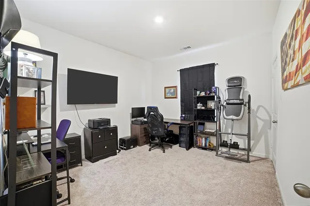 a view of a workspace with furniture and a window