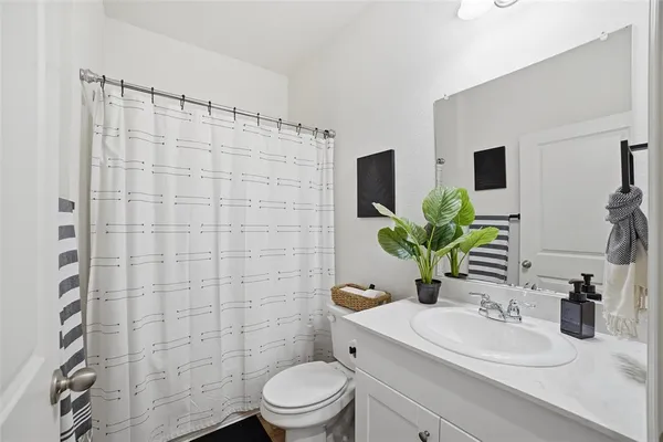 a bathroom with a sink a toilet a mirror and shower