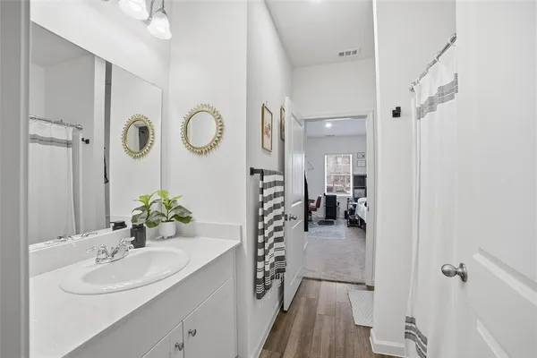 a en suite bathroom with a shower sink and mirror