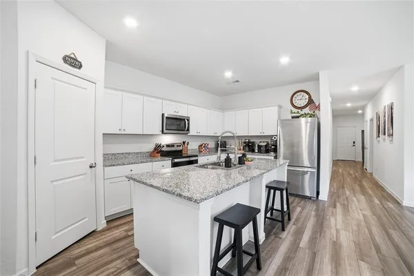 a kitchen with a table chairs refrigerator and microwave