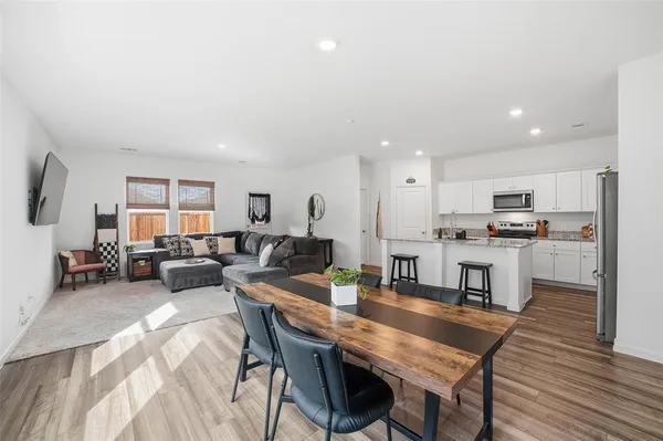 a living room with lots of furniture and kitchen view
