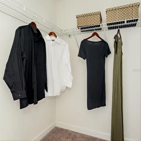 a view of walk in closet with clothes and shoes