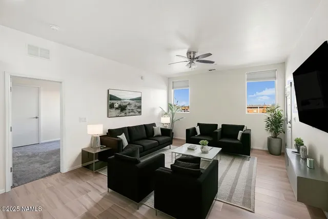 a living room with furniture a flat screen tv and a fireplace