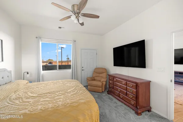 a bedroom with a bed and a flat screen tv