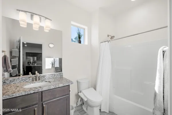 a bathroom with a granite countertop sink toilet and shower