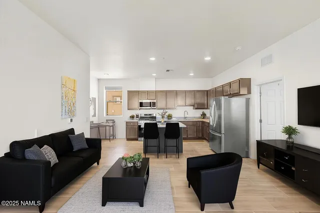 a living room with furniture kitchen view and a refrigerator