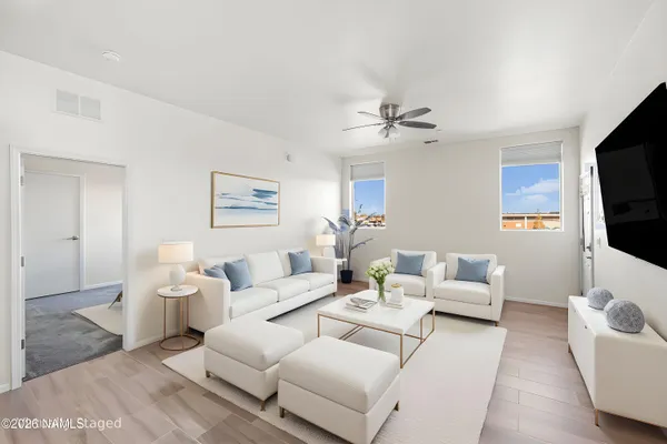a living room with furniture a flat screen tv and white walls