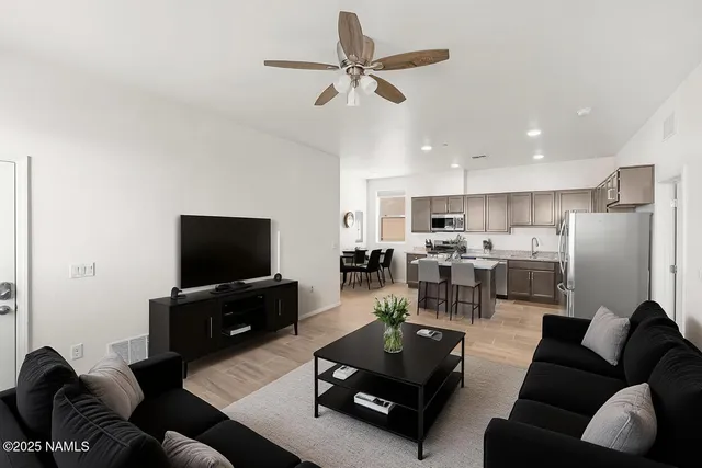 a living room with furniture kitchen view and a flat screen tv