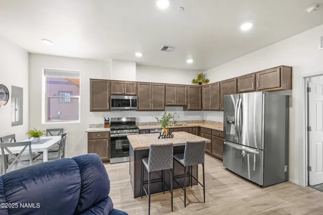 a living room with stainless steel appliances kitchen island furniture and wooden floor