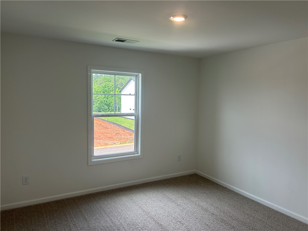 217 Bellflower Lane Anderson, SC 29625 - Photo 21 of 27 A window frames verdant outdoor scenery in this carpeted room.