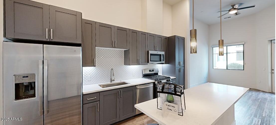 15501 North Dial Boulevard, Unit A1 Scottsdale, AZ 85260 - Photo 2 of 24 a kitchen with stainless steel appliances a refrigerator a sink a stove and white cabinets with wooden floor