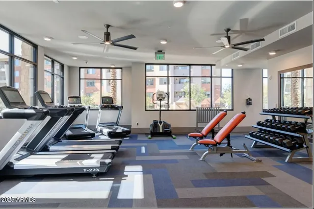 a room with gym equipment and wooden floor