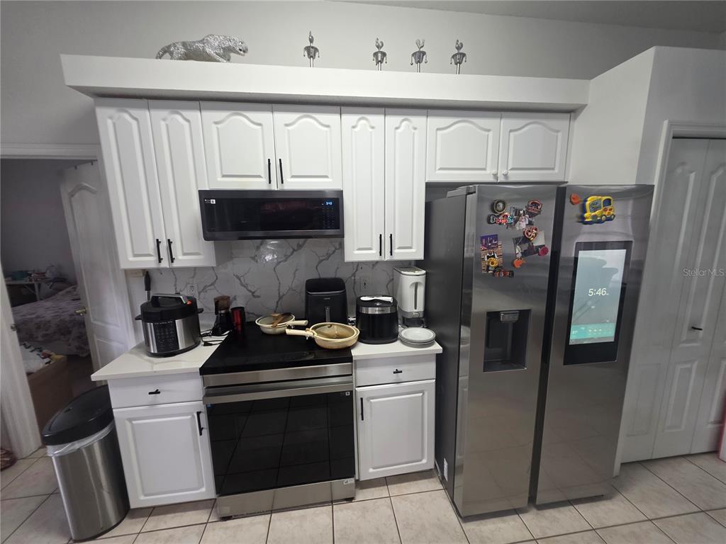 17820 Monteverde Drive Spring Hill, FL 34610 - Photo 13 of 42 a kitchen with stainless steel appliances a refrigerator a stove a sink and a microwave
