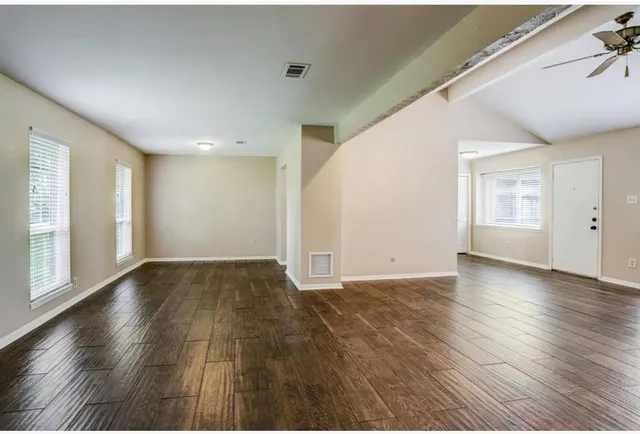 wooden floor in an empty room with a window