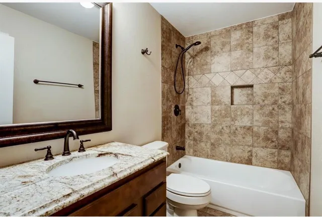 a bathroom with a granite countertop sink toilet and shower