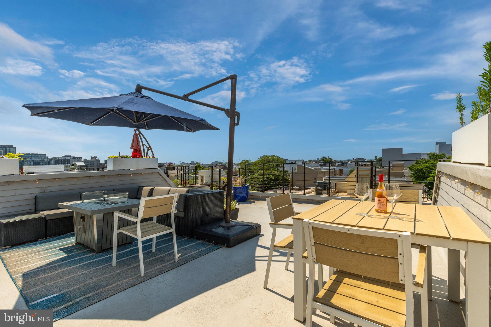 1733 Carpenter Street, Unit D Philadelphia, PA 19146 - Photo 37 of 37 a view of a roof deck with table and chairs under an umbrella