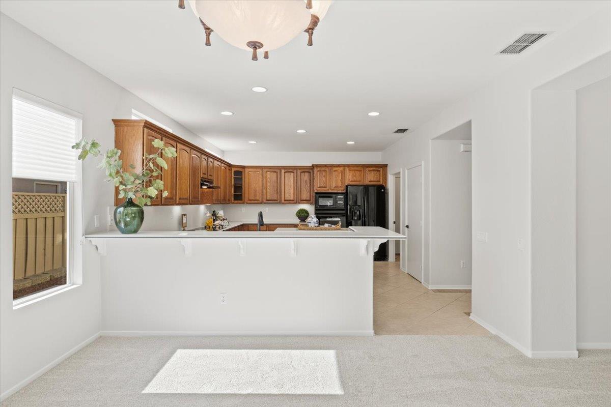 851 Rocky Ridge Lane Lincoln, CA 95648 - Photo 9 of 31 a living room with stainless steel appliances kitchen island granite countertop a refrigerator a stove a sink a microwave oven with white cabinets and wooden floor