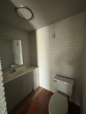 a bathroom with a toilet sink a mirror and vanity