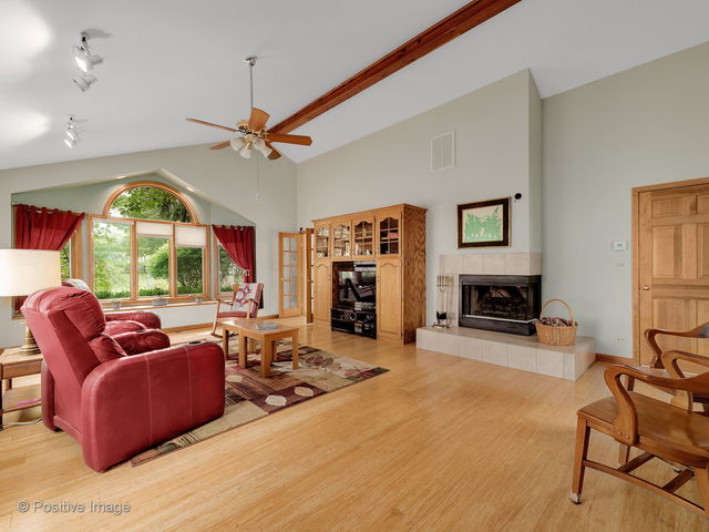 28W241 Garys Mill Road Winfield, IL 60190 - Photo 3 of 34 a living room with furniture a fireplace and a flat screen tv