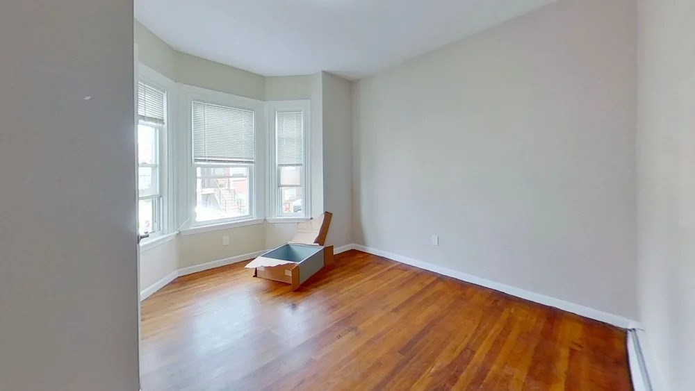 121 George Street, Unit 1 Boston, MA 02119 - Photo 5 of 7 a view of empty room with wooden floor and fan