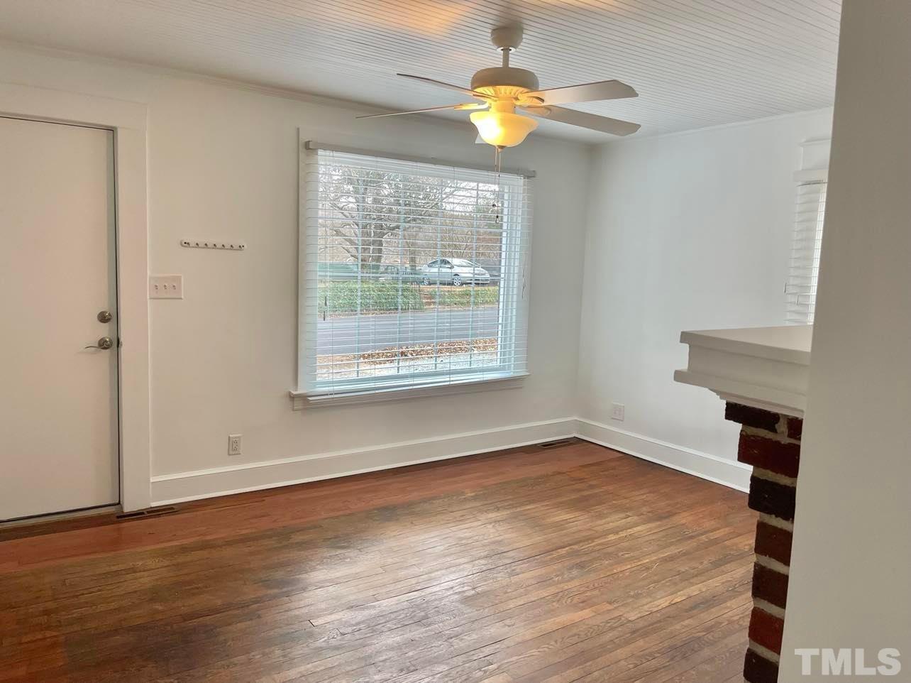 207 Broad Street Roxboro, NC 27573 - Photo 17 of 17 an empty room with wooden floor chandelier fan and windows