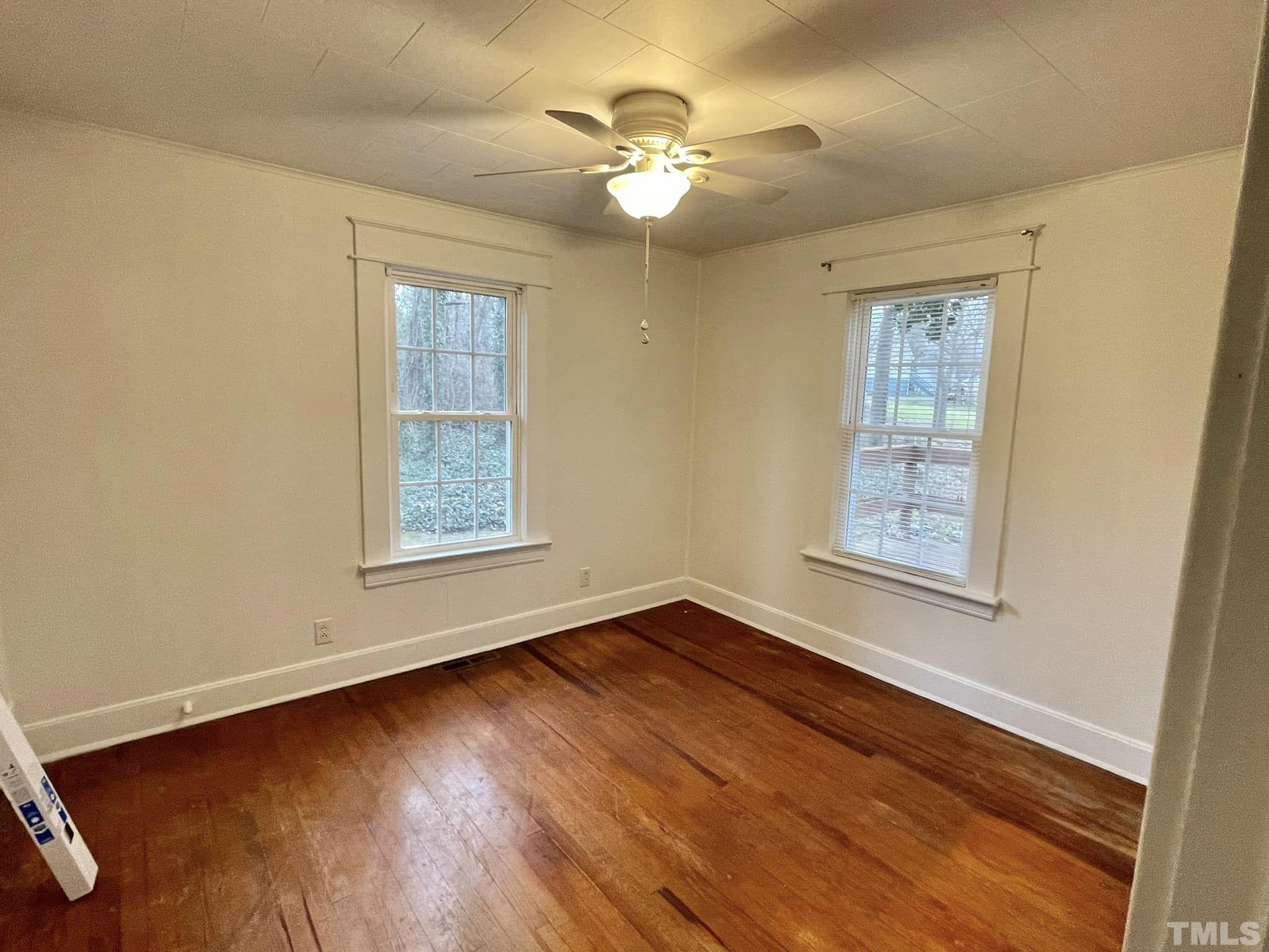 207 Broad Street Roxboro, NC 27573 - Photo 6 of 17 a view of an empty room with wooden floor and a window