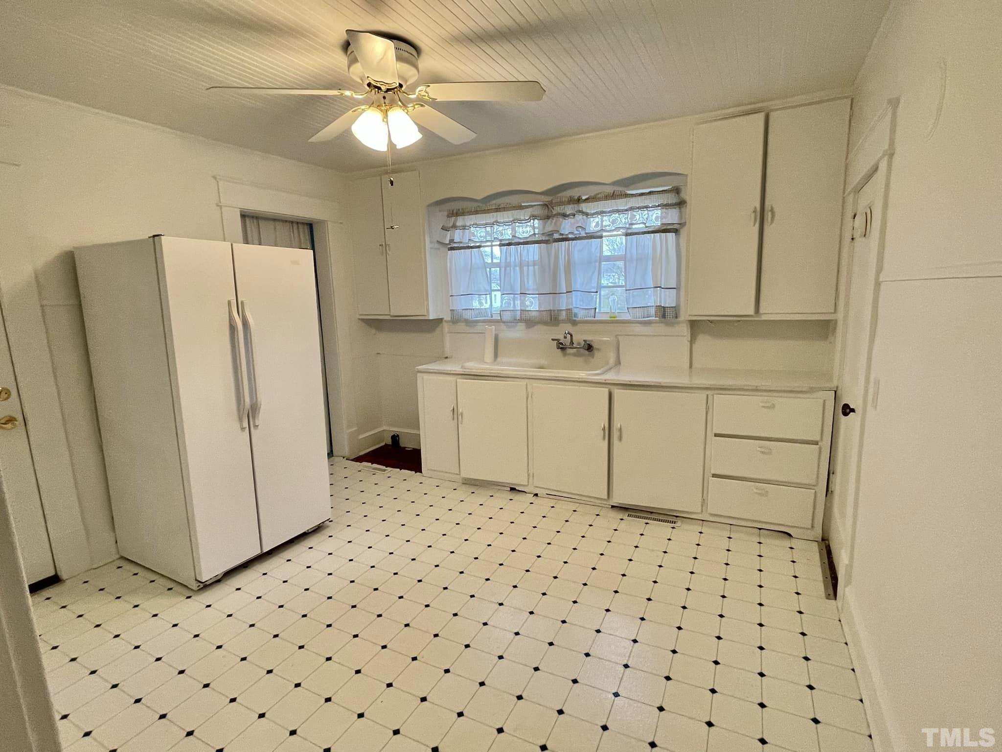 207 Broad Street Roxboro, NC 27573 - Photo 8 of 17 a room with a refrigerator and a dresser