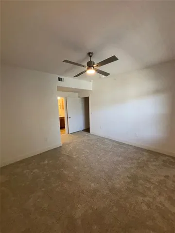 an empty room with a ceiling fan and a window