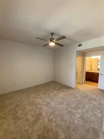 an empty room with a ceiling fan and window