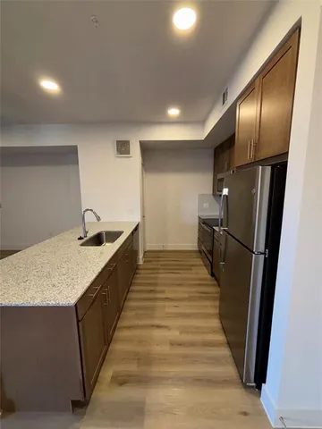 a kitchen with stainless steel appliances granite countertop refrigerator a sink and wooden floor