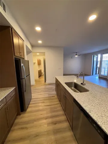 a large kitchen with granite countertop a sink and stainless steel appliances