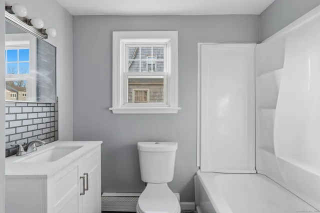a bathroom with a sink a toilet and shower