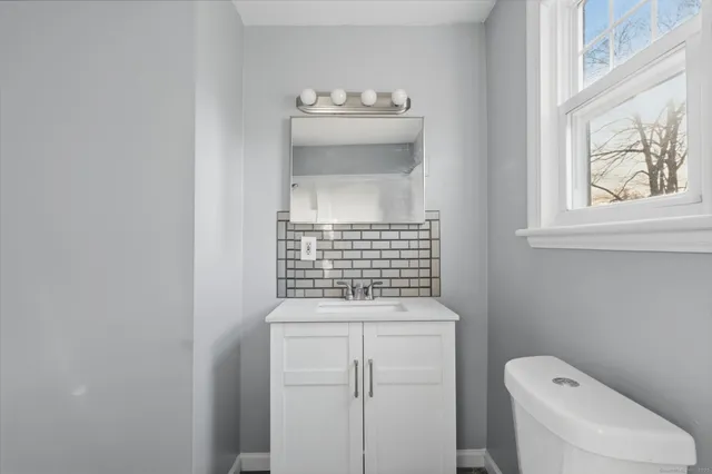 a bathroom with a sink a toilet and window