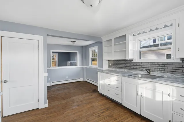 a kitchen with granite countertop white cabinets and white appliances