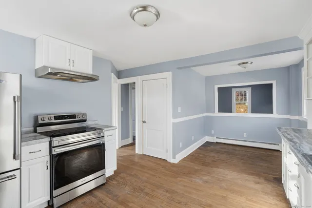 a kitchen with wooden floors and stainless steel appliances