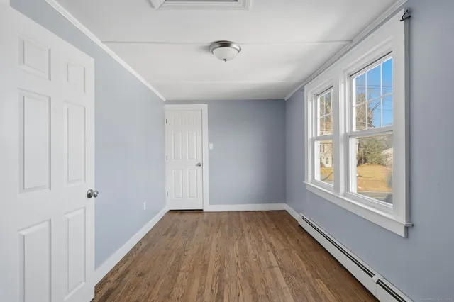 a view of a room with wooden floor and windows